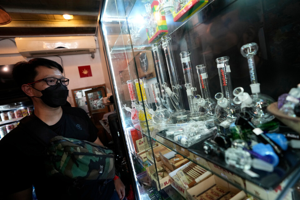 En kund tittar på varor på ett kafé som säljer cannabis i Bangkok på torsdagen.
