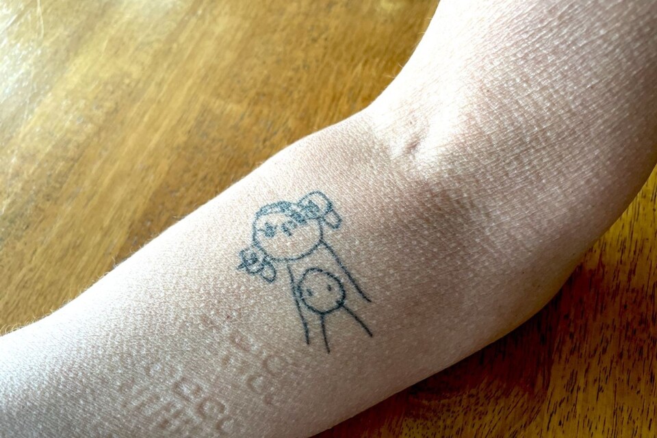 På Marias arm finns en tatuering av en teckning som Fredrik ritat som barn. ”Det är jag och Fredrik”, säger Maria.