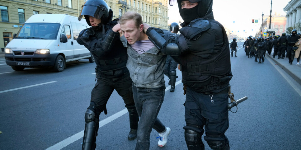 Ryska kravallpoliser för iväg en demonstrant i S:t Petersburg på lördagen.