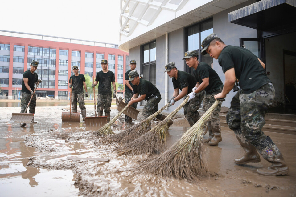 Poliser städar upp slam efter översvämningar i Hebei-provinsen.
