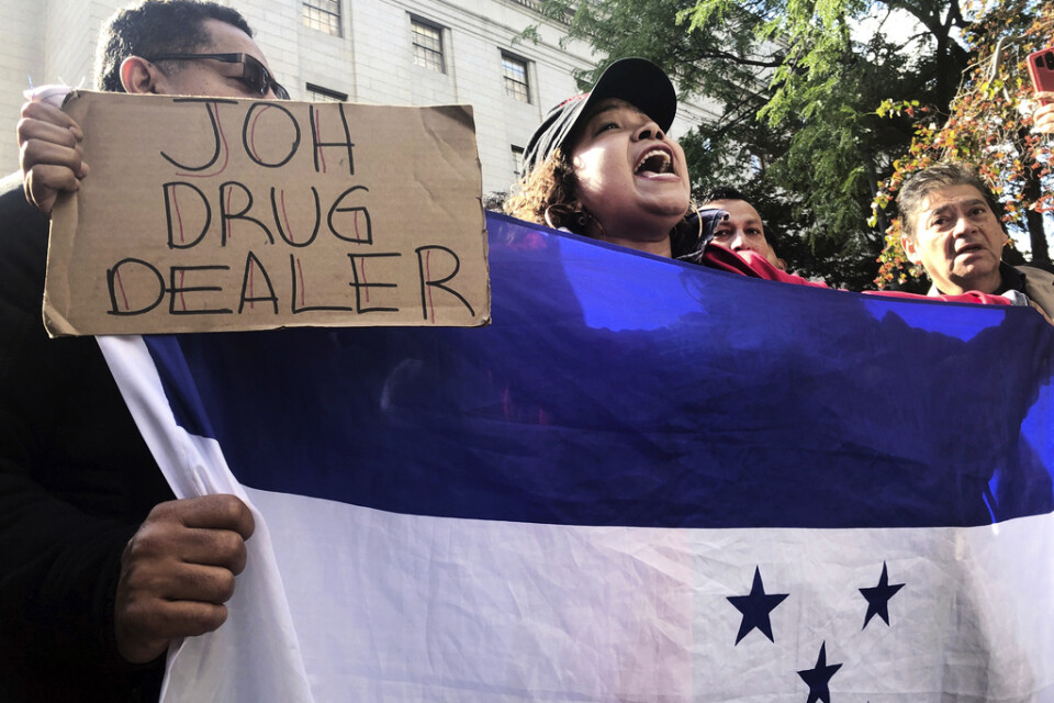 Exilhonduraner firar utanför domstolen i New York med skyltar som anklagar president Juan Orlando Hernández för narkotikahandel.