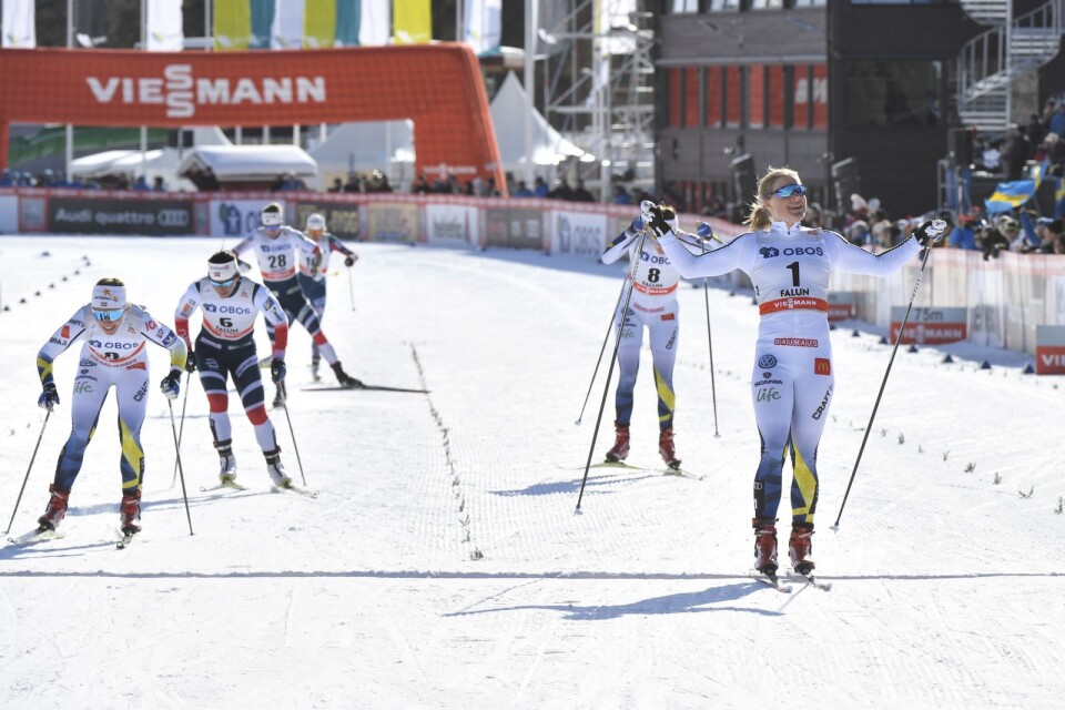 Hanna Falk är så överlägsen att hon kan kosta på sig en segergest när hon glider över mållinjen som världscupsegrare i Falun.