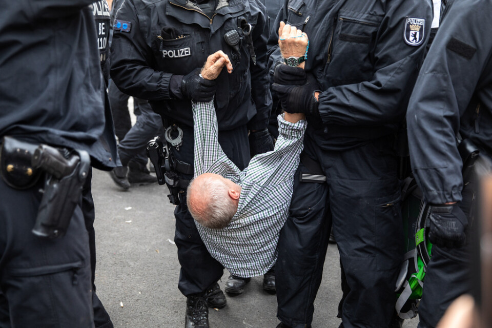 Polisen släpar iväg en man under en demonstration mot covidrestriktioner. Bilden är från en annan protest, i Berlin i fjol.