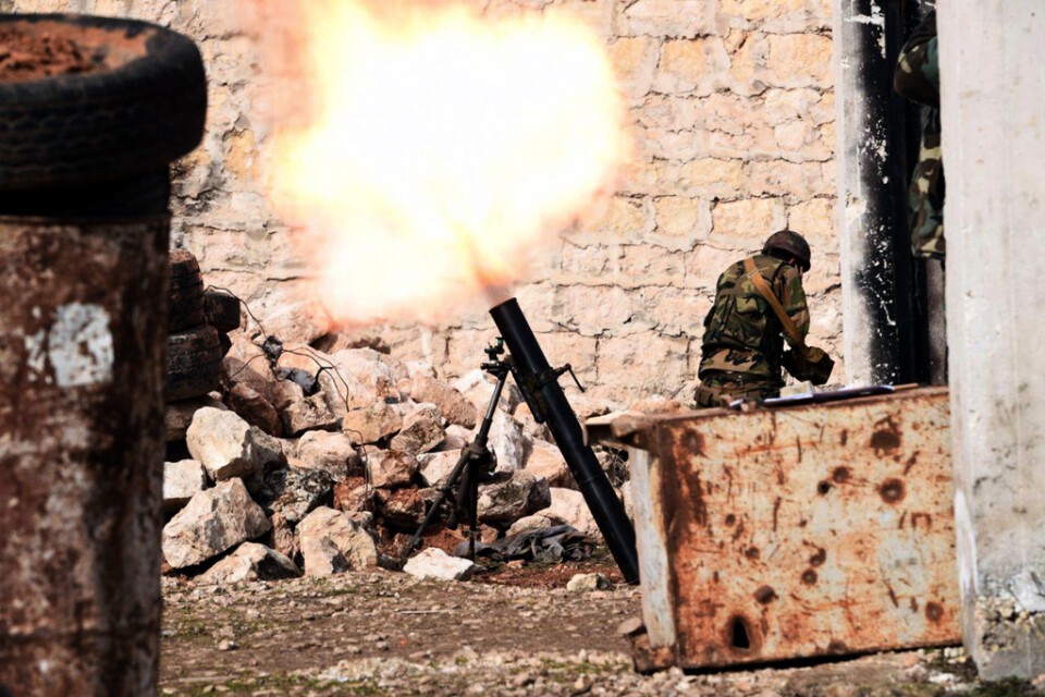 En bild från den statliga syriska nyhetsbyrån Sana den 27 januari visar en regeringssoldat som avfyrar en granat i västra Aleppo.