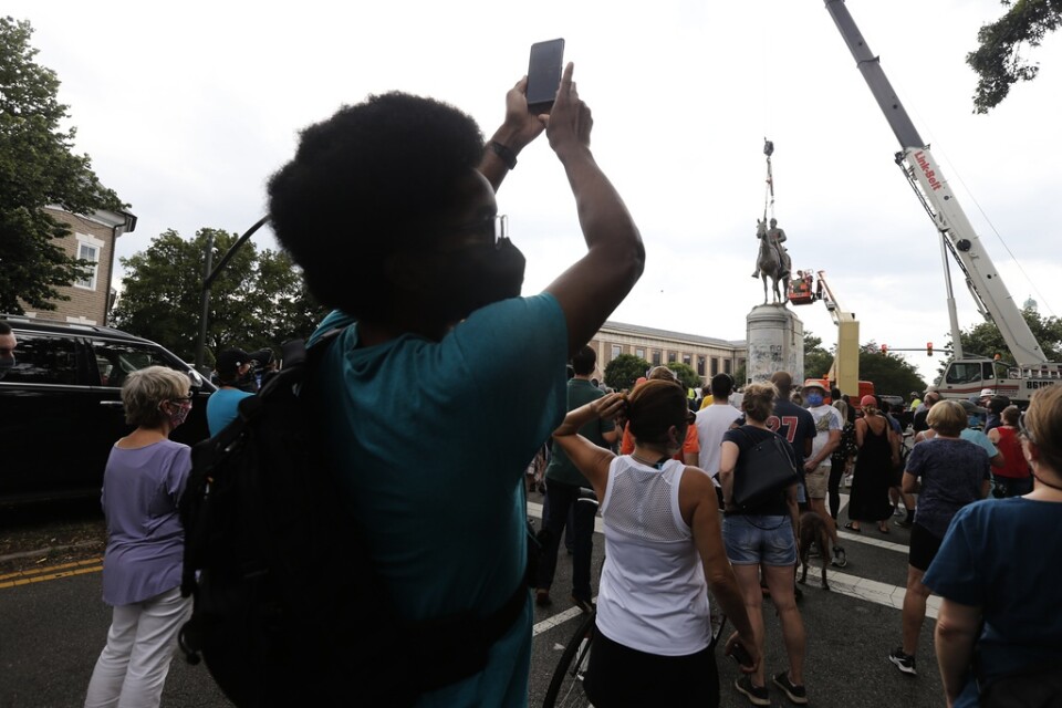 Demonstranter tittar på när statyn av sydstatsgeneralen Thomas "Stonewall" Jackson rivs i Richmond, Virginia.
