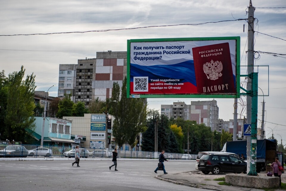 "Hur skaffar man ett rysk pass?" Reklamskylt i Luhansk inför de så kallade folkomröstningar om att bli en del av Ryssland som anordnades i flera ockuperade delar av Ukraina i fjol. Arkivbild.