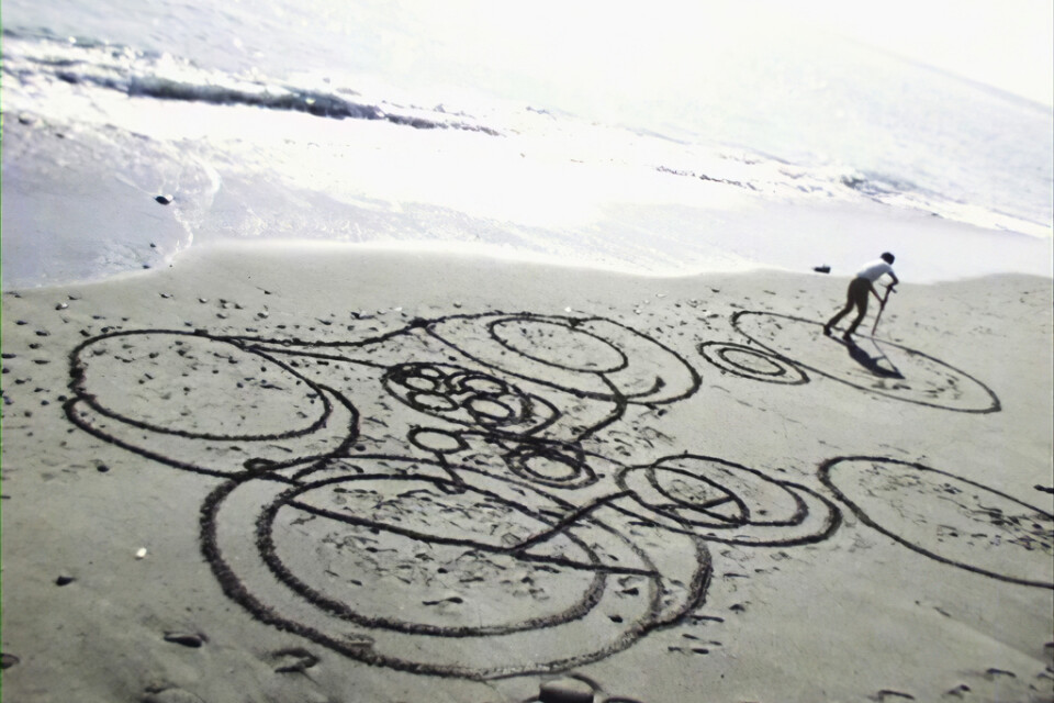 Ur filmen ”Round on sand” (1968) där Atsuko Tanaka tecknar cirklar i sanden medan vågorna sköljer in. Pressbild.