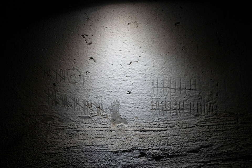 Inristade streck – troligen ristade för att räkna dagar – på väggen i en källare som användes som en rysk tortyrkammare i Cherson. Bild från december 2022.