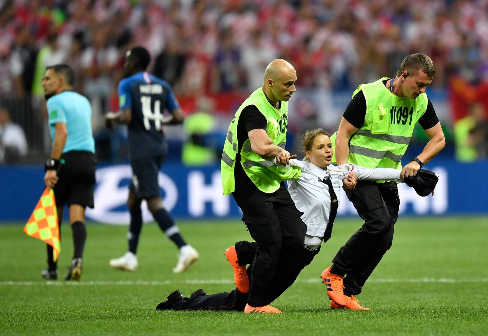 Stewards pull a woman off the pitch after she stormed onto the field and interrupted the final match between France and Croatia at the 2018 soccer World Cup in the Luzhniki Stadium in Moscow, Russia, Sunday, July 15, 2018. (AP Photo/Martin Meissner)