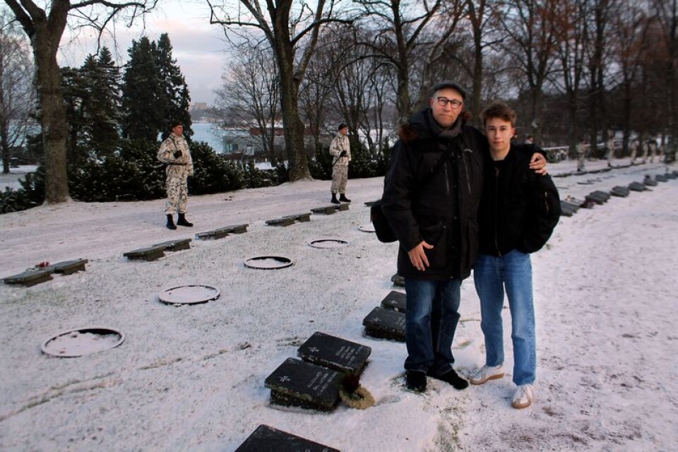 Pappa Marrko Taina och hans son Eino efter att de lagt en liten krans på gravstenen efter Markkos morfar Emil Laitinen som föll offer under Vinterkrigets slutskede. Foto: Lars Näslund.