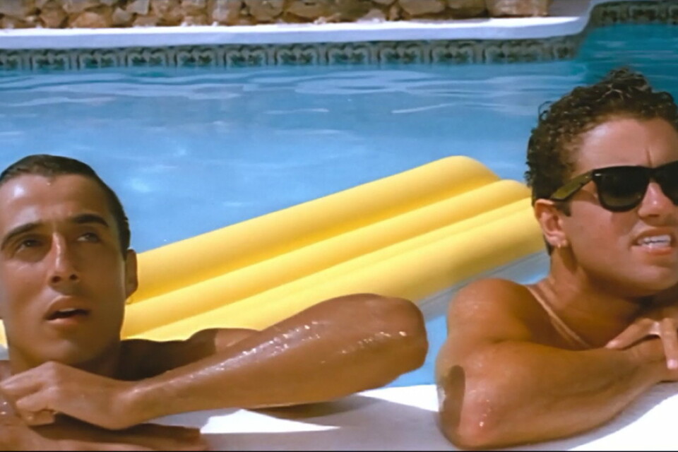 Andrew Ridgeley (till vänster) och George Michael under inspelningen av musikvideon till Wham-låten "Club Tropicana". Duons berättelse skildras i nya dokumentären "Wham" på Netflix. Pressbild