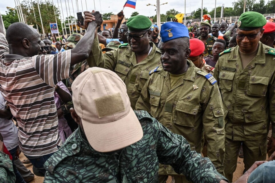 Några av juntaledarna i Niger hälsas välkomna av en folkmassa i huvudstaden Niamey i söndags.