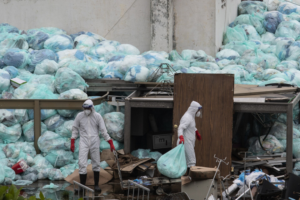 Vårdarbetare i skyddsutrustning slänger sopor utanför ett sjukhus i delstaten Veracruz i Mexiko, där covid-patienter behandlas.