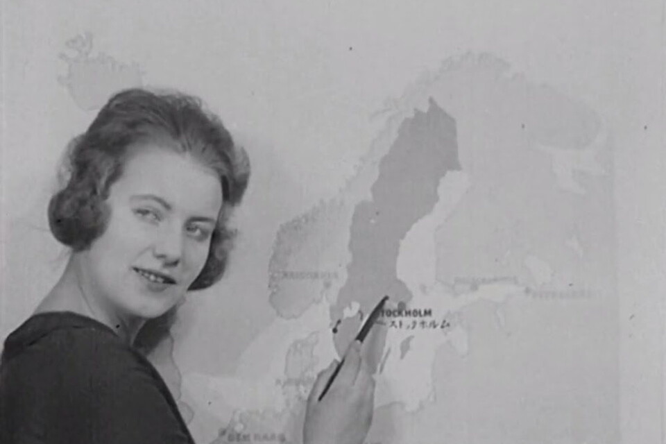 Bild ur en informationsfilm från 1920 där Greta Garbo pekar ut svenska industrier på en karta.