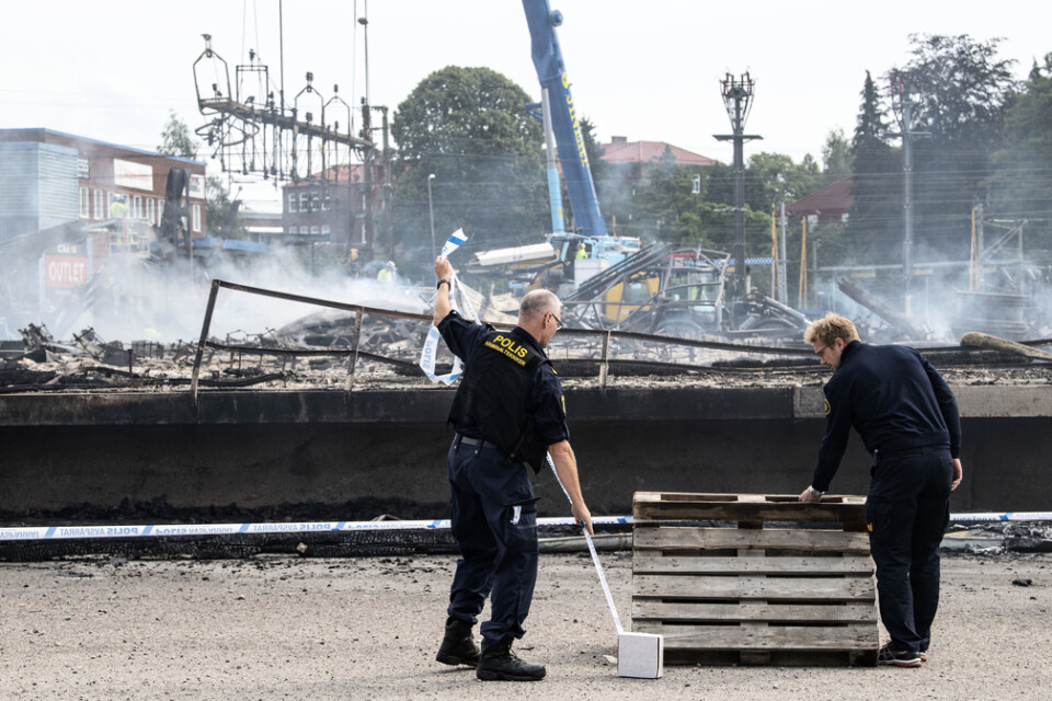 Polisens kriminaltekniker spärrar av medan de skadade kontaktledningarna och signalsystemkablarna demonteras och röjs undan strax norr om Hässleholm C efter en kraftig brand i augusti i en industribyggnad. Arkivbild.