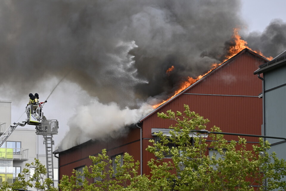 Räddningstjänsten på plats vid ett flerfamiljshus på Munkhättegatan i Malmö och bekämpar en vindsbrand.