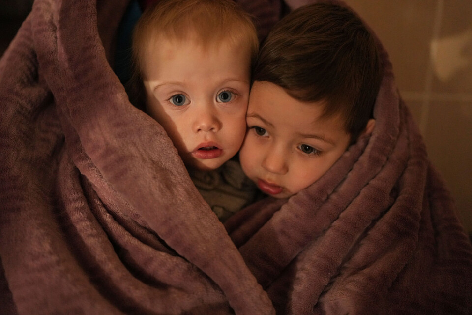 Barn värmer sig på ett sjukhus i Mariupol i Ukraina. Arkivfoto.