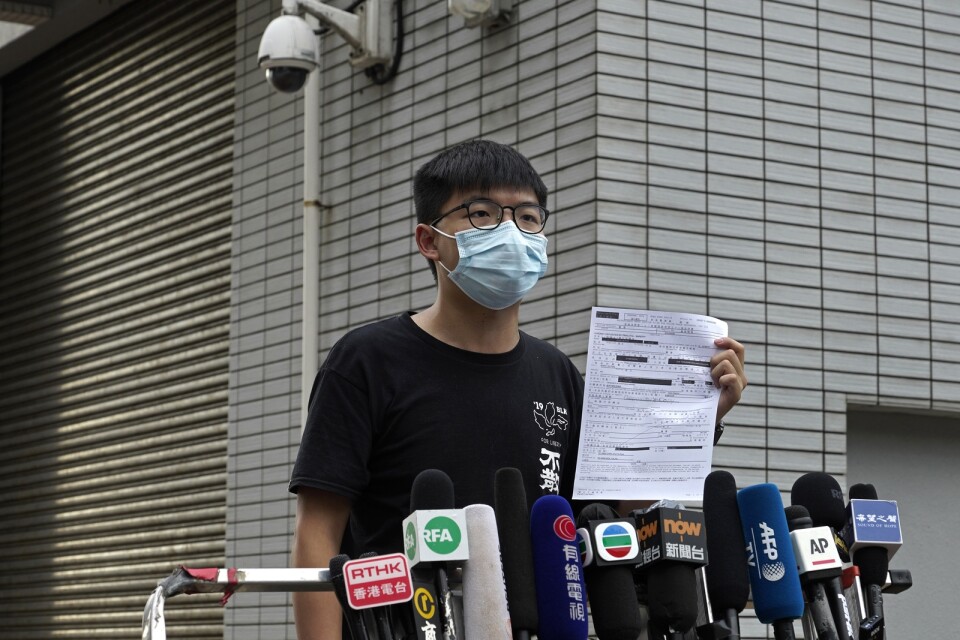 Joshua Wong, en av de mest framträdande demokratiaktivisterna i Hongkong, möter ett pressuppbåd utanför polisstationen efter att ha släppts mot borgen.