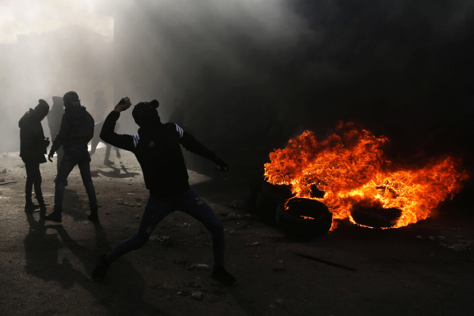 Palestinier kastar sten mot polisen i närheten av staden Qalqilya på Västbanken på fredagen.
