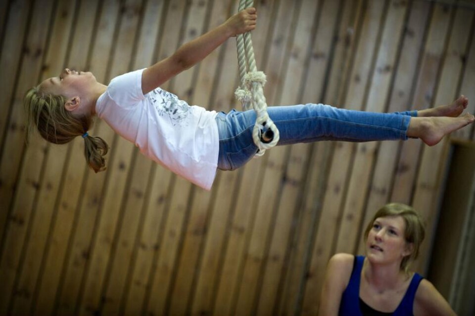 Elin Gren övar i trapetsen medan ledaren Anja Nilsson instruerar.