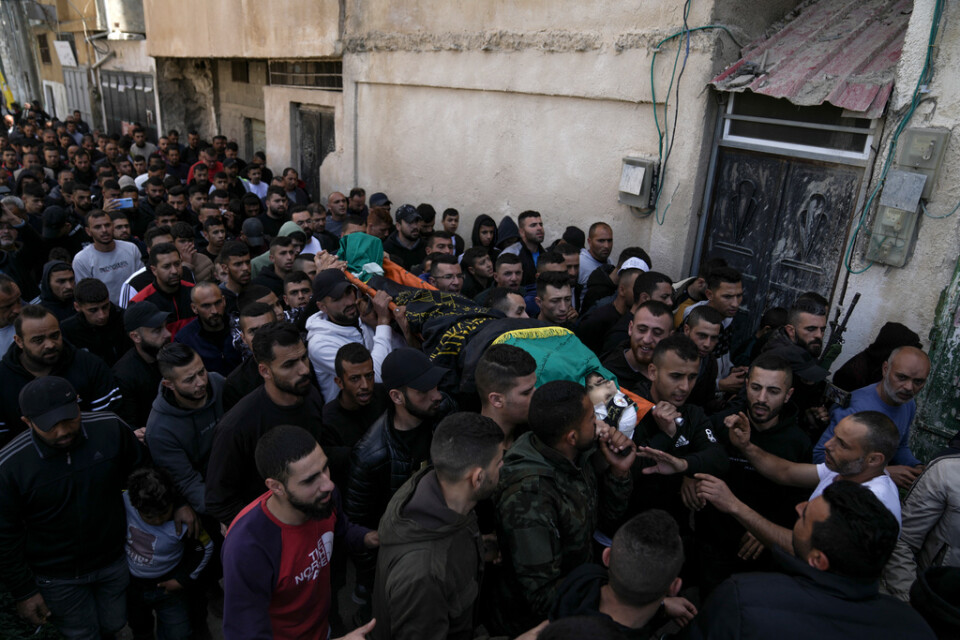 Sörjande bär en av de palestinier som dödades i torsdagens israeliska räd i Jaba på Västbanken. Kroppen är draperad i den väpnade gruppen Islamiska jihads flagga.