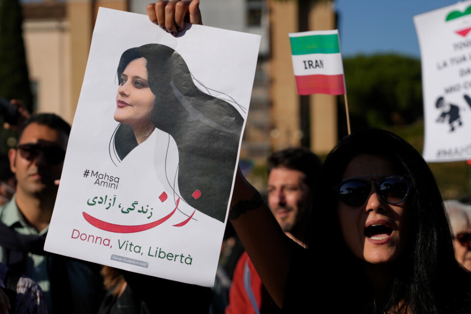 Demonstranter i Italiens huvudstad Rom håller upp en skylt med en bild på Mahsa Zhina Amini, som dog i den iranska moralpolisens förvar i september. Arkivbild.