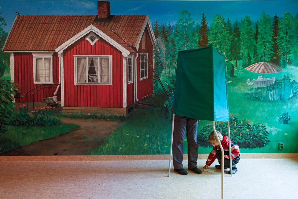 Kvinna röstar bakom skärm i Sofiebergsskolan i Trollbäcken i Tyresö medans hennes barn plockar med valsedel på golvet. Lyssnar man på dagens unga verkar den politiska debatten bli annorlunda i framtiden.