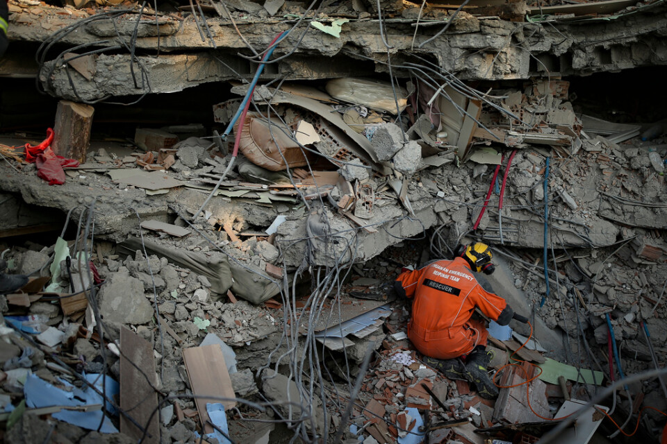En turkisk räddningsarbetare söker igenom en kollapsad byggnad i Adiyaman i södra Turkiet på lördagen.
