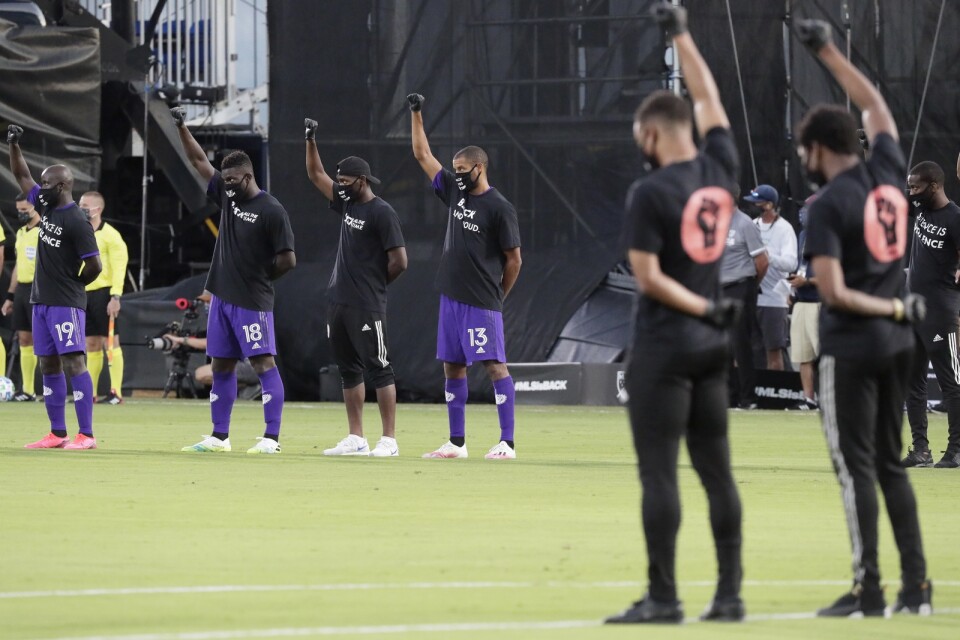 Orlandos spelare, till vänster, höjde sina nävar i protest mot rasistiskt våld före matchen.