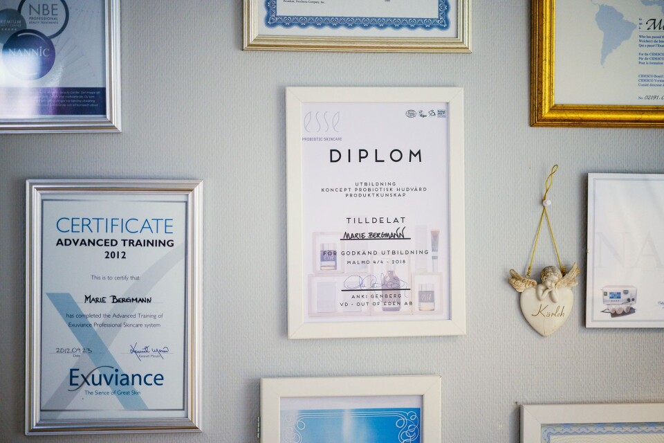 På en av väggarna i salongen hänger flera diplom och certifikat.