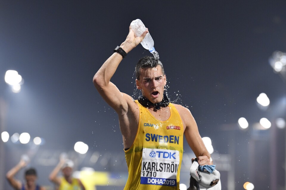 Perseus Karlström – med "iskorven" runt halsen – svalkar sig med vatten under gångtävlingen i friidrotts-VM i Doha 2019. Arkivbild.