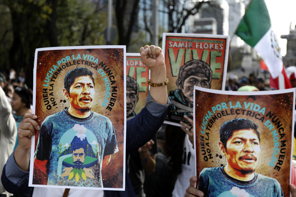 Människor håller upp bilder på en mördad aktivist, Samir Flores Soberanes, vid en manifestation i Mexikos huvudstad Mexico City.