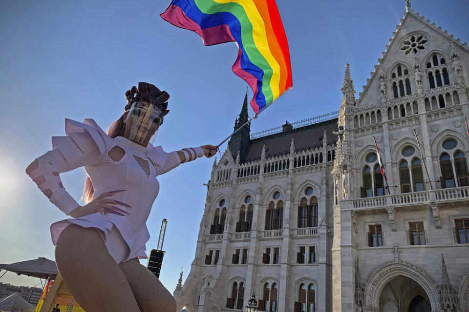 En regnbågsflagga hålls upp i en protest utanför parlamentet i Budapest, som i tisdags godkände en omstridd ny lag som förbjuder "främjandet av homosexualitet" i Ungern.