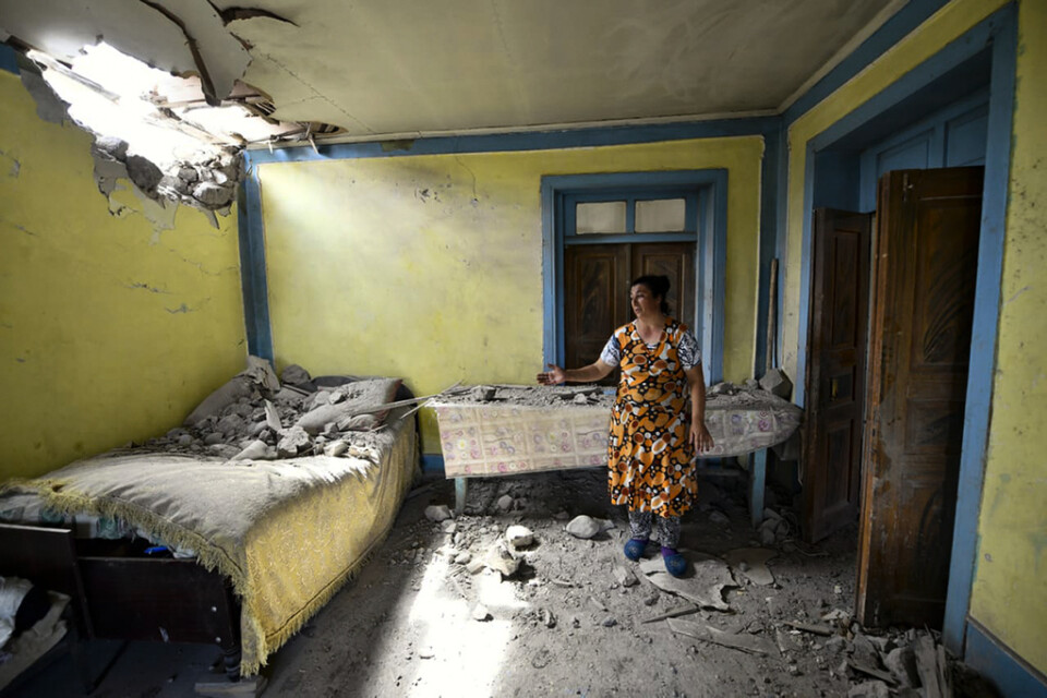 En kvinna i den azeriska Tovuz Rayonu-distriktet visar upp sitt hem som skadats i den senaste tidens stridigheter mellan Armenien och Azerbajdzjan. Arkivbild.