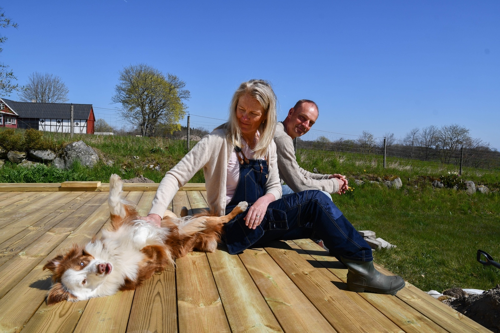 Hunden Hedda tillsammans med Madeleine och Björn Åsbrink på nya altanen, ett av många projekt som paret hunnit med under det senaste året.