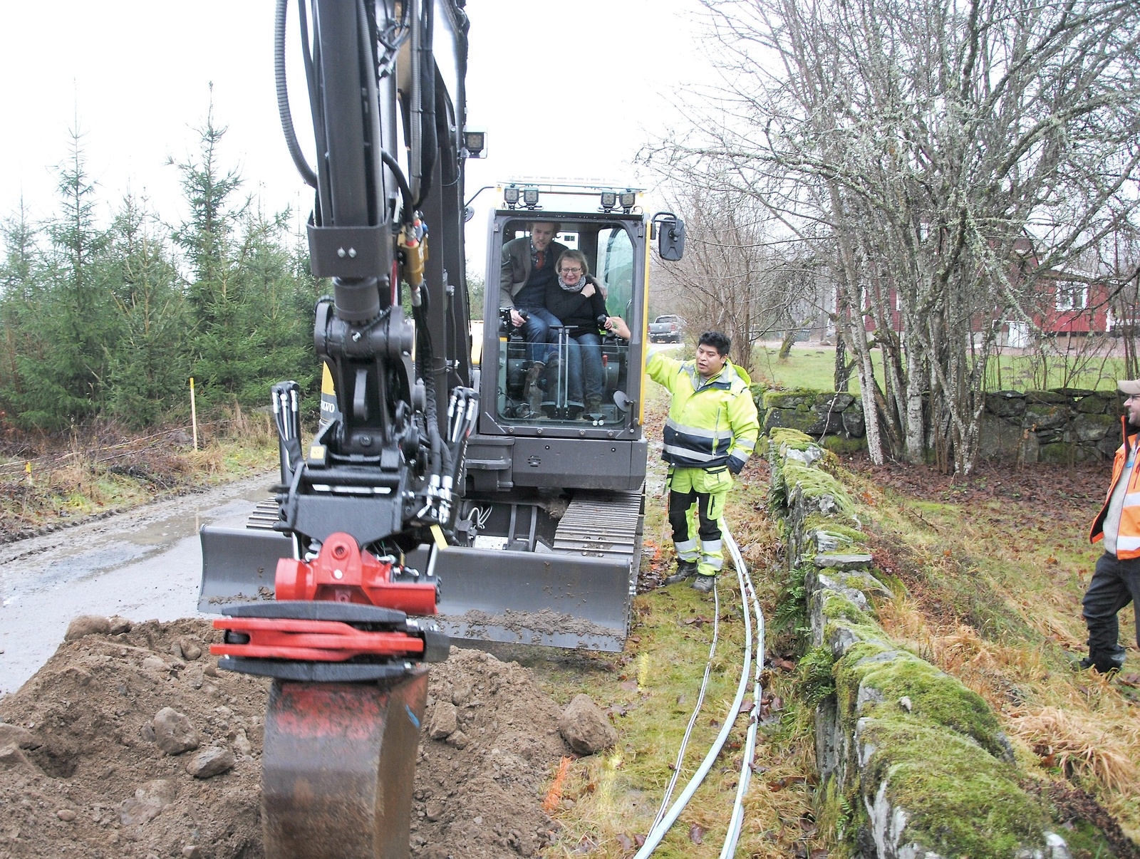 Daniel Jönsson (M) och Ingrid Persson tar en symboliskt första spadtag - eller grävmaskinstag, rättare sagt - när arbetet med att gräva ner fiber inleds på landsbygden i norra Östra Göinge.