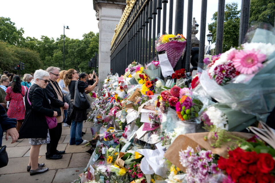 Människor lämnar blommor utanför Buckingham Palace i London med anledning av drottning Elizabeth bortgång.