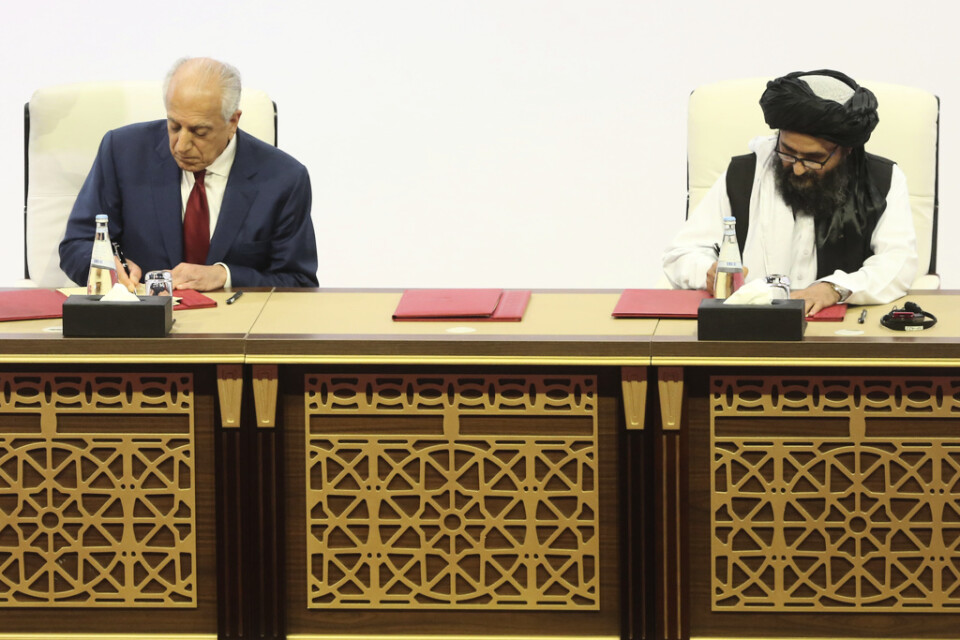 USA:s särskilde sändebud Zalmay Khalilzad och talibanrörelsens chefsförhandlare Abdul Ghani Baradar skakar hand efter att ha undertecknat ett avtal mellan parterna i Doha i Qatar den 29 februari.