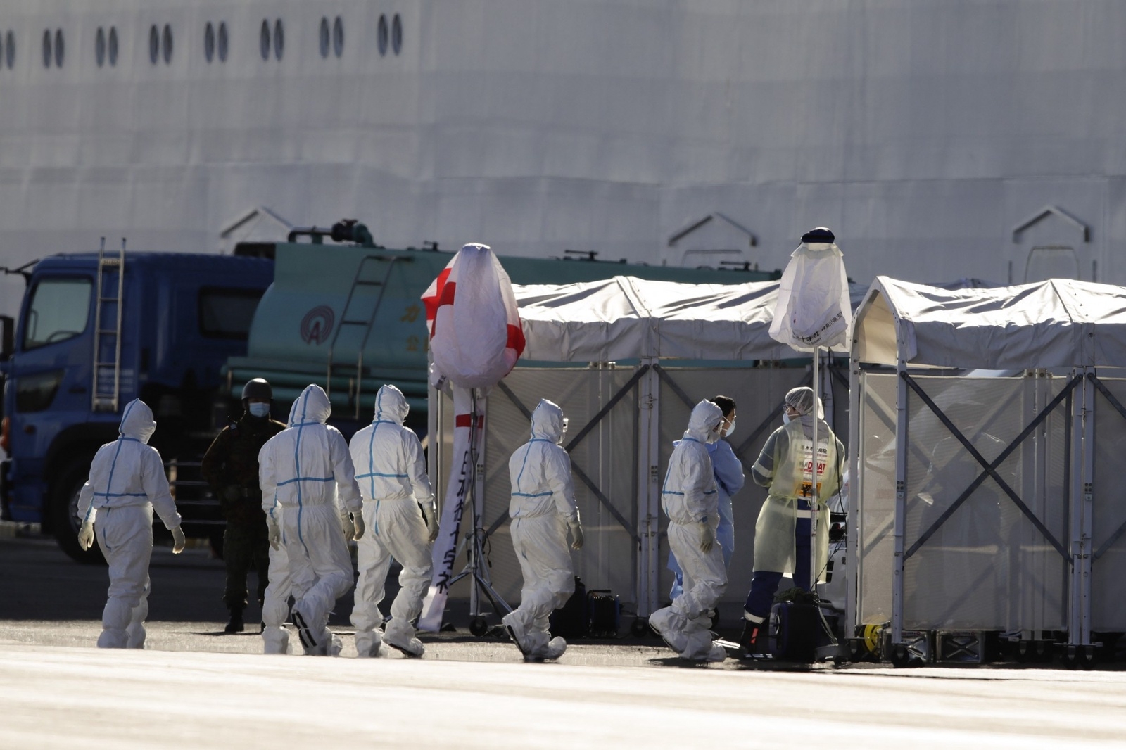 Medical workers with protective suites enter the quarantined Diamond Princess cruise ship docked in the Yokohama Port in Yokohama, near Tokyo, Tuesday, Feb. 11, 2020. Japan's Health Minister Katsunobu Kato said the government was considering testing everyone remaining on board and crew on the Diamond Princess, which would require them to remain aboard until results were available. (AP Photo/Jae C. Hong)  XJH104