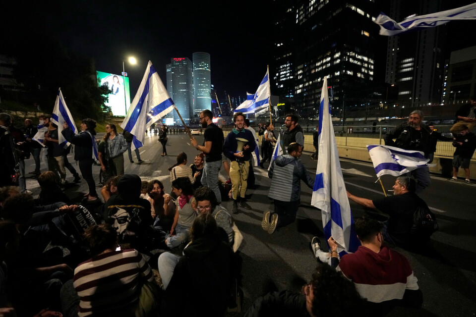 Israeler blockerar en motorväg utanför Tel Aviv i protest mot regeringens förslag att ändra rättsväsendet.