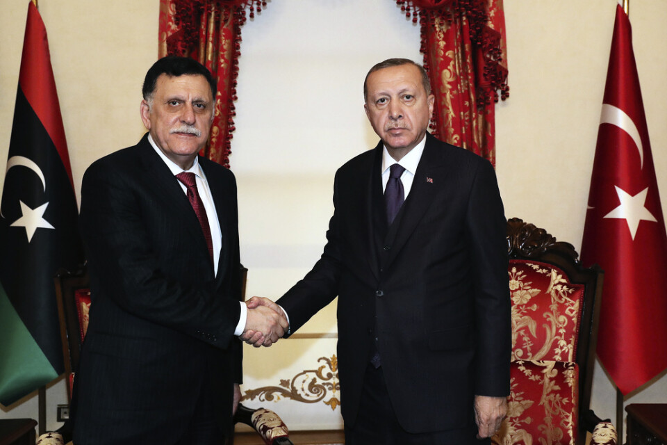 Turkiets president Recep Tayyip Erdogan, till höger, skakar hand med Libyens internationellt erkända regerings premiärminister, Fayez al-Sarraj, under ett möte i Istanbul den 15 december.