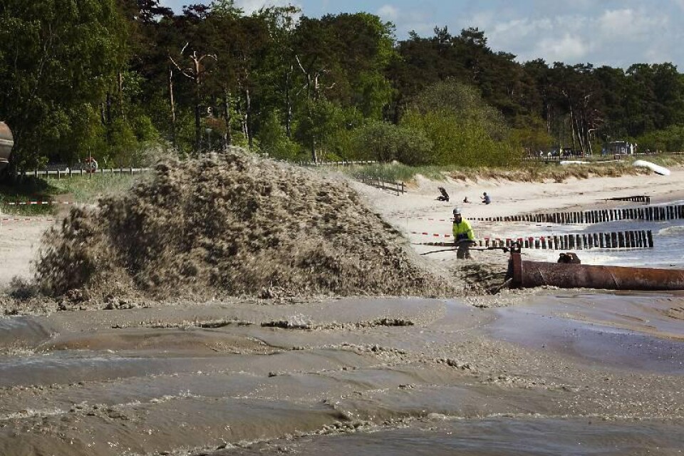 Sanden blandas med vatten för att sprutas upp på stranden genom rörledningen den dryga kilometern från fartyget Magni R, uppkallat efter vikingaguden Tors son. Den sju man starka besättningen på Magni R arbetar i skiftet dygnet runt. Foto: Bass Nilsson