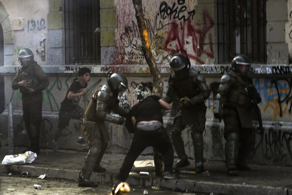 Poliser i drabbning med demonstranter i Chiles huvudstad Santiago den 6 december.