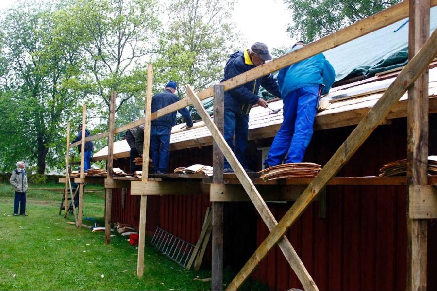 Första snickardagen med regn. Medlemmar från Vegbys hembygdsförening lägger tak.
