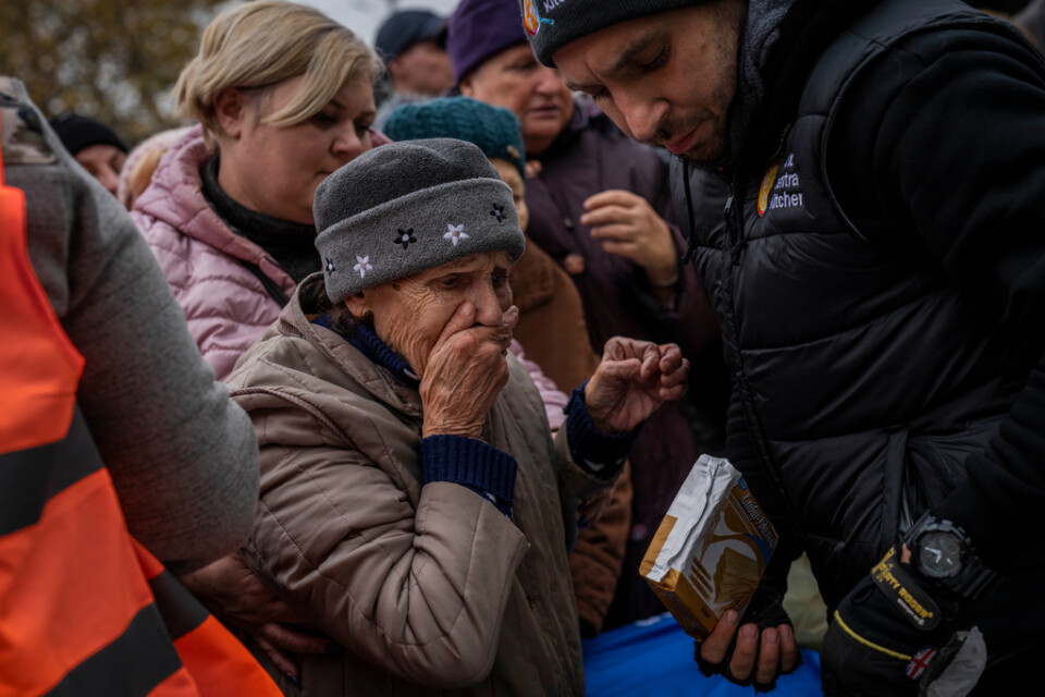 En kvinna tar emot ett paket med donerade livsmedel i Cherson efter det ryska tillbakadragandet i november.