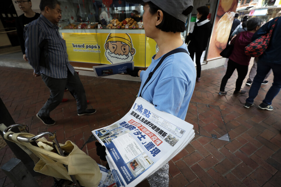 En tidning med uppgifter om det nya lungviruset säljs i Hongkong.