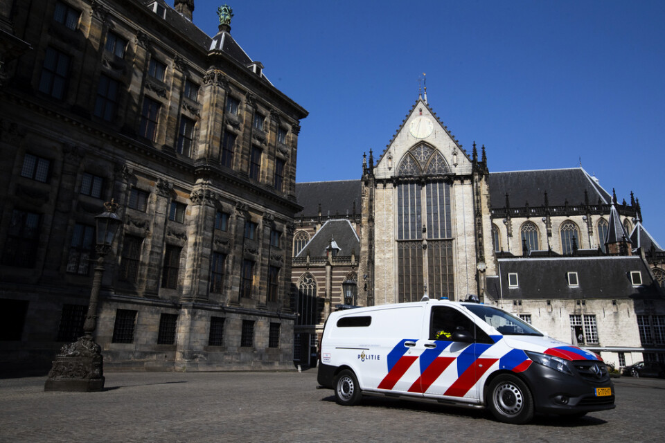 En polisbil håller ett öga på stillheten framför Kungliga slottet i Amsterdam (till vänster). Nederländerna är liksom merparten av världen näst intill nedstängt av coronaviruset. Arkivfoto.