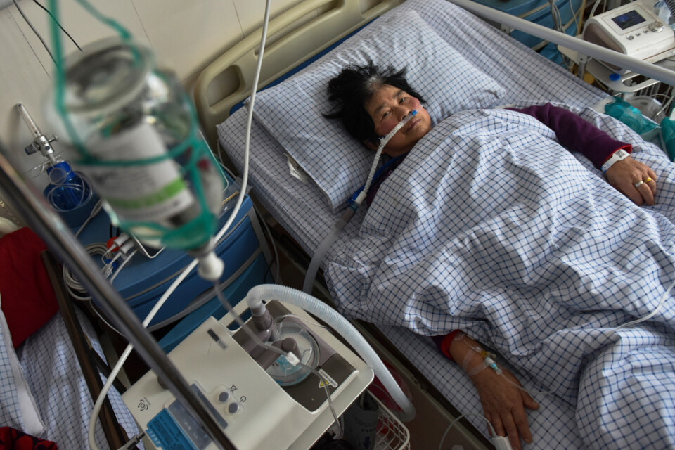 En kvinna med covidsymtom får intravenös dropp och syrgas via en näsgrimma på en akutavdelning på ett sjukhus i Fuyang den 4 januari.