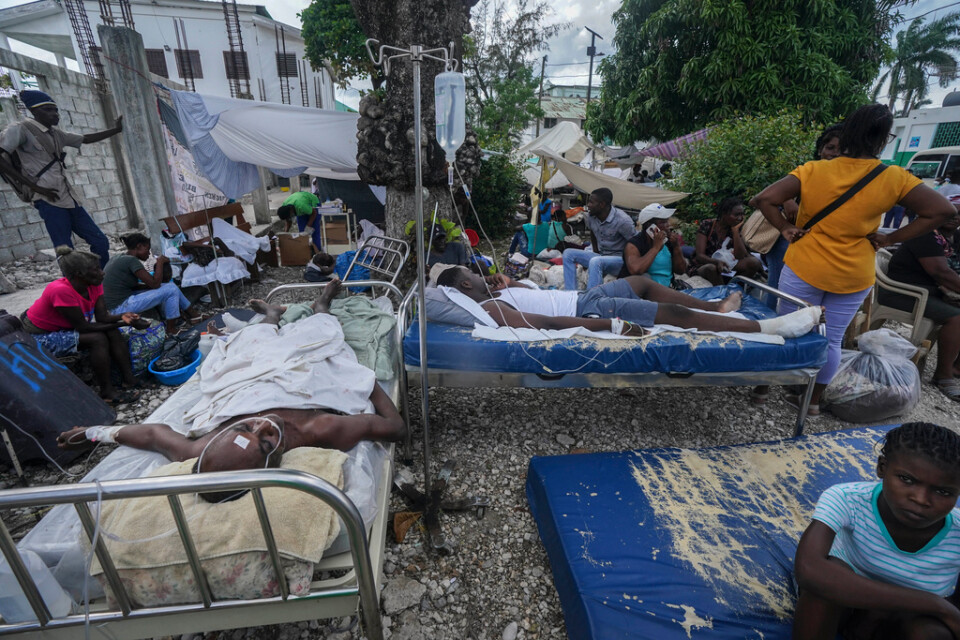 Skadade efter lördagens jordskalv vårdas utomhus i Les Cayes.