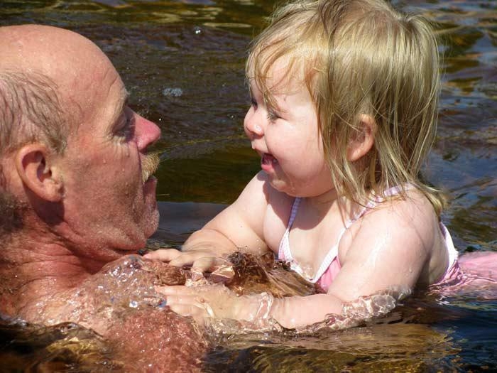 Mycket spännande, men oh, så härligt. Tindra badar med morfar Tomas i Överlida. Foto: Yvonne Östanbäck, Fritsla.